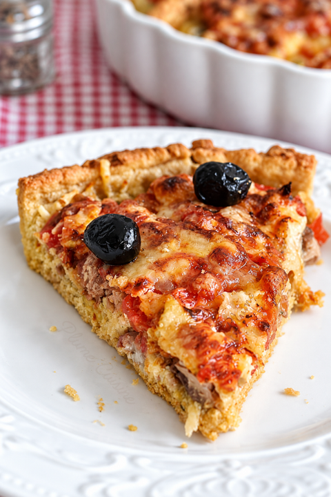 Part de tarte au thon et à la moutarde sur nappe à carreaux rouges