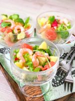 Délicieuse salade de crevettes dressée dans un verre à glace, avec crevettes, pamplemousse rose, avocat, pomme verte, salade croquante.
