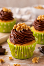 Cupcakes vanille et glaçage chocolat à la crème chocolat onctueuse, servis dans de jolies caissettes vertes.