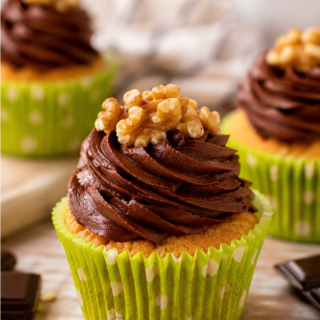 Cupcakes vanille et glaçage chocolat à la crème chocolat onctueuse, servis dans de jolies caissettes vertes.