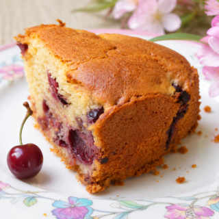 Tranche de gâteau moelleux aux cerises fraîches sur une assiette vintage,