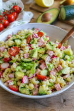 Salade de pâtes à l'avocat et au jambon dans une assiette blanche