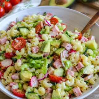 Salade de pâtes à l'avocat et au jambon dans une assiette blanche