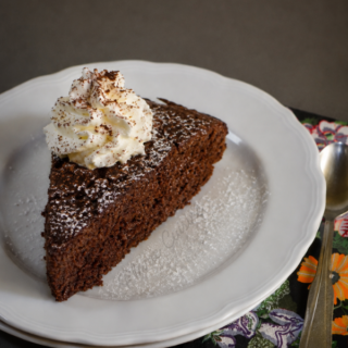 Gâteau au chocolat avec du chocolat en poudre garni de chantilly et légèrement saupoudré de sucre glace