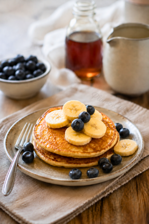 Trois pancakes moelleux sur une assiette.