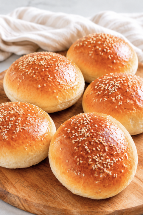 Pains à hamburger maison moelleux sur une planche en bois