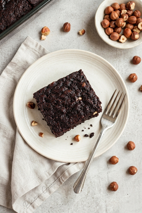 Brownie au chocolat et aux courgettes sur une assiette blanche.