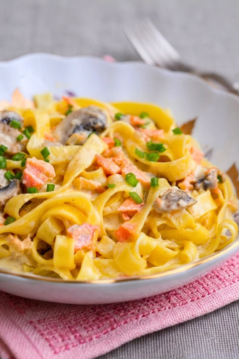 Pâtes crémeuses au saumon et champignons photographiées en gros plan.