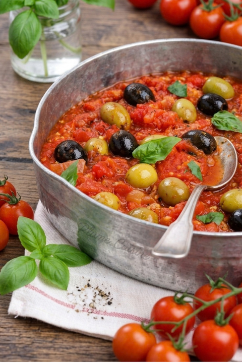 Sauce tomate aux olives vertes et noires pour pâtes dans une petite casserole.