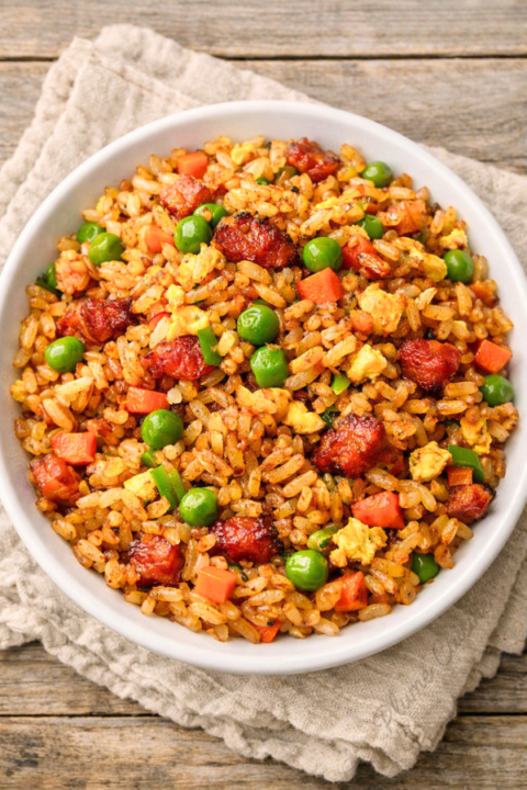 Riz cantonais aux lardons servi dans une assiette blanche