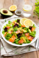 Salade de saumon et avocat présentée dans une assiette blanche.