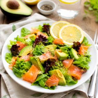 Salade de saumon et avocat présentée dans une assiette blanche.