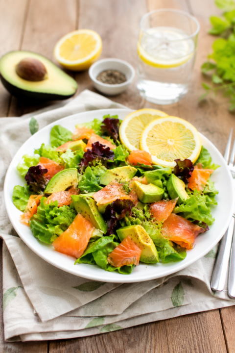 Salade de saumon et avocat dans une assiette blanche.