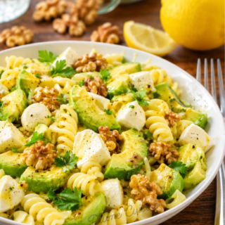 Assiette généreuse de salade de pâtes, avocat, mozzarella et noix