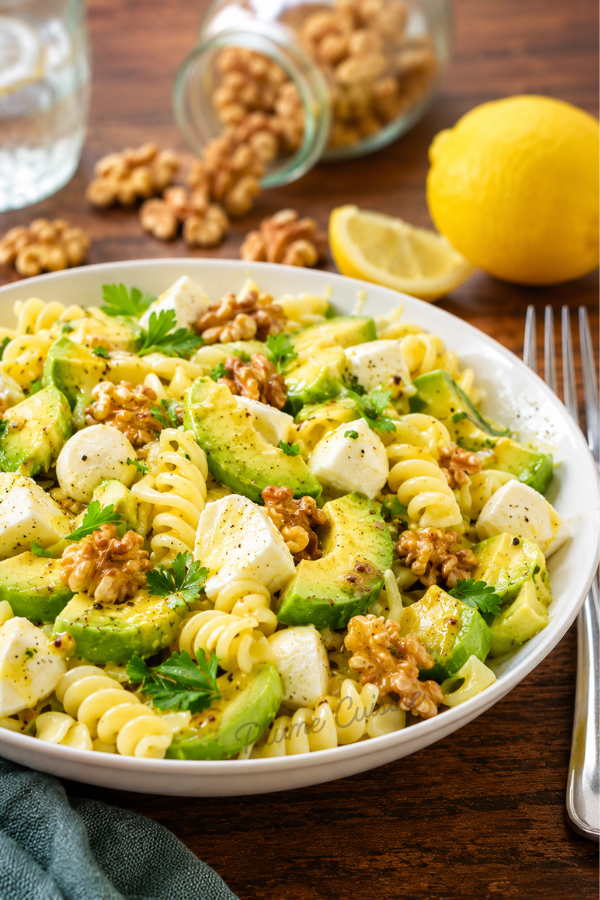 Assiette généreuse de salade de pâtes, avocat, mozzarella et noix