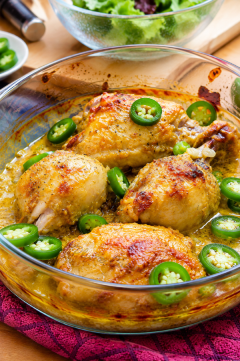 Poulet au curry au four, morceaux de poulets dans un plat en verre.