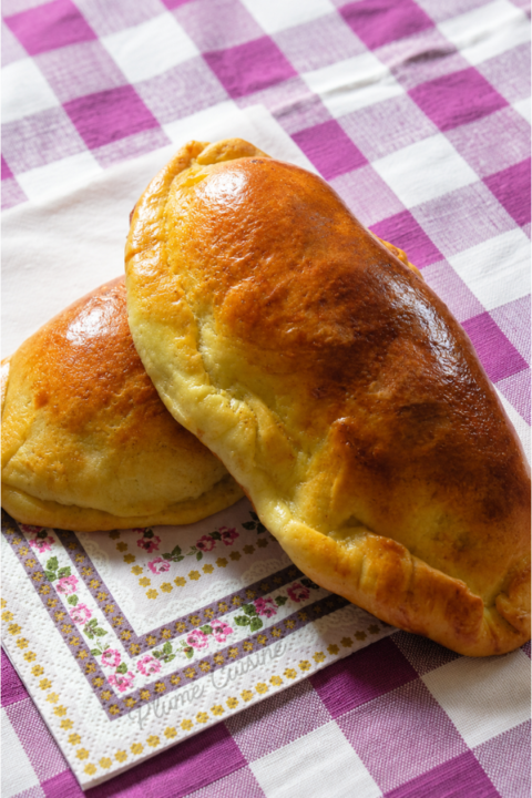Pirogues à la viande maison dorées et moelleuses sur une assiette blanche
