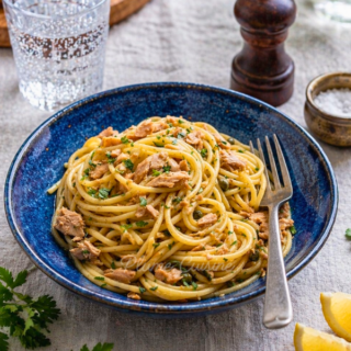 Pâtes au thon à l'ail dressés dans une belle assiette bleue