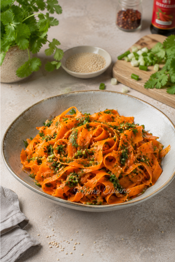 Une assiette de salade de carottes coréenne parsemée de coriandre