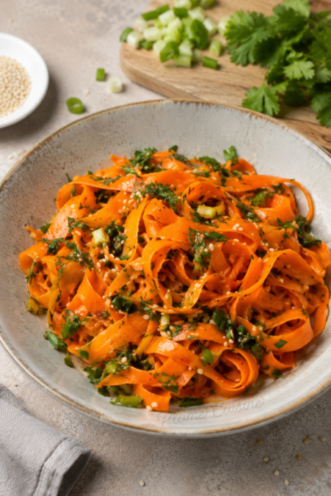 Assiette de salade de carottes coréenne avec coriandre fraîche et graines de sésame grillées
