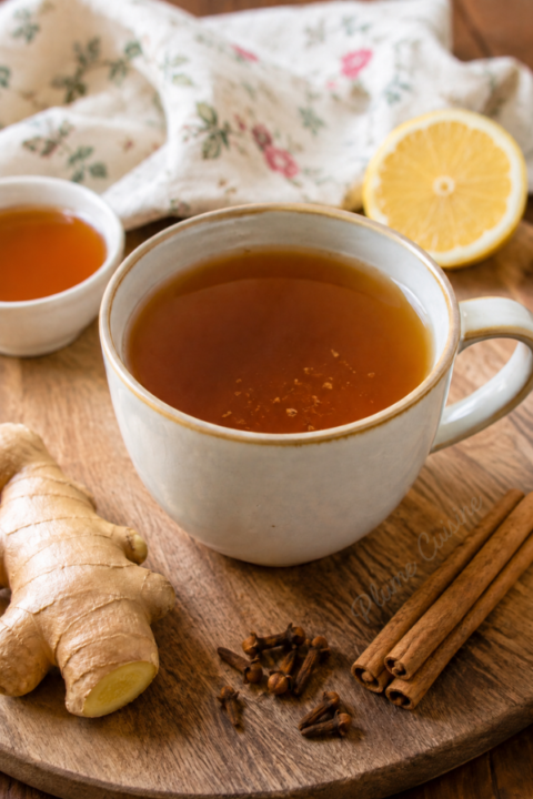 Thé gingembre cannelle et clous de girofle dans une tasse beige
