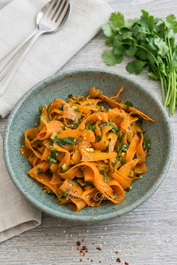 Salade de carottes coréenne servie dans un bol avec coriandre fraîche et sauce soja.