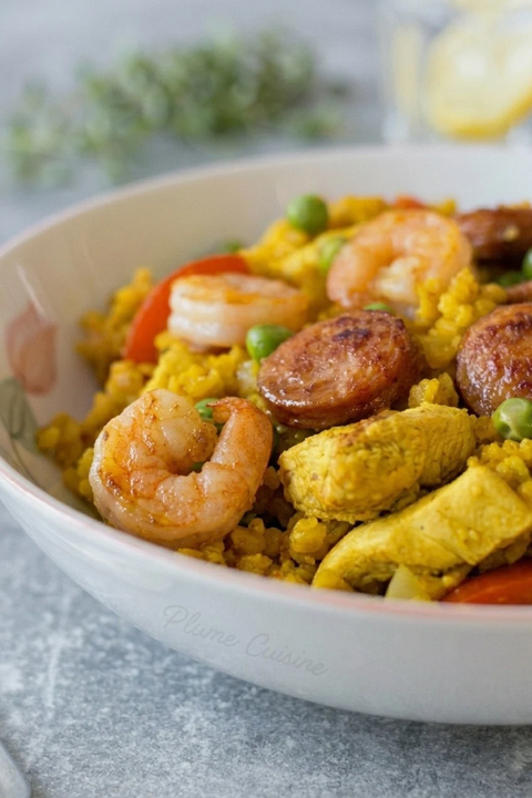 Gros plan sur une assiette de paella à l'ebly faite maison avec crevettes et chorizo.